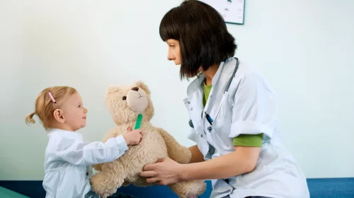 pediatrician-playing-with-child-doctors-office_329181-9274